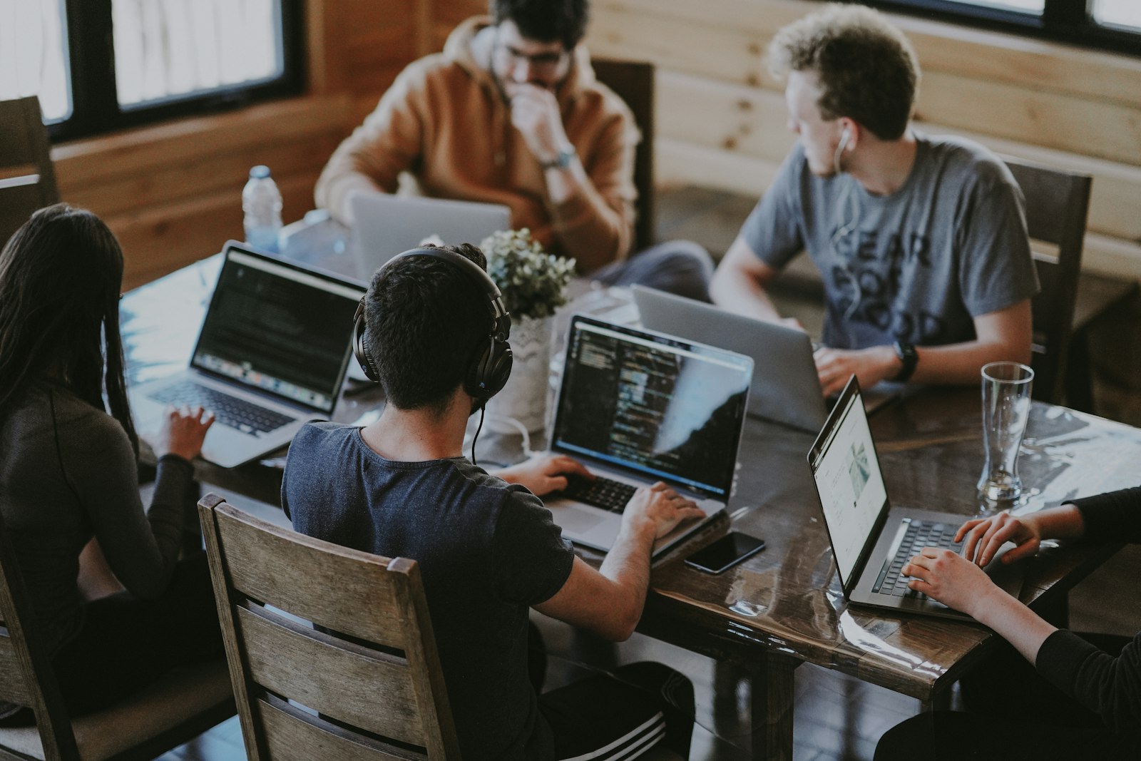 Traders working side by side on laptops around a table